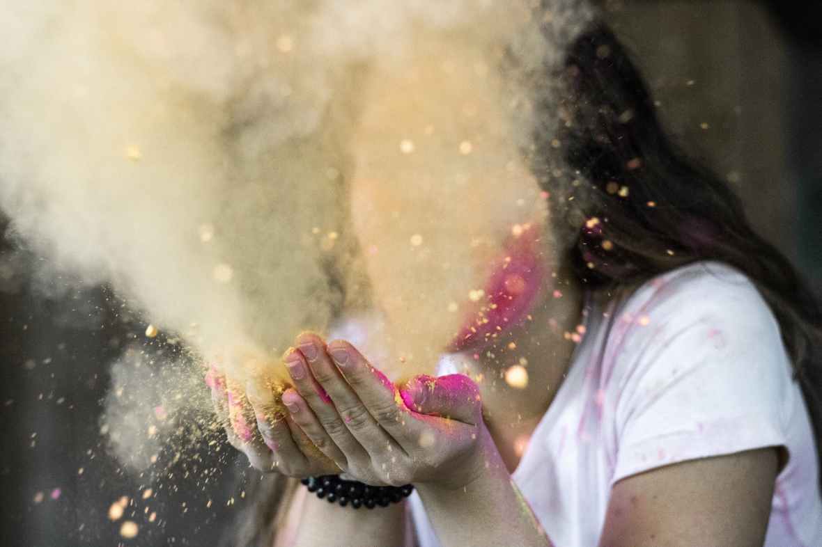 woman in white cap sleeved shirt blowing dust